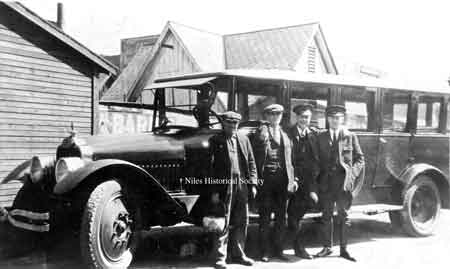 The Niles Car barn bus belonged to the Mahoning Valley Electric Railway Company. It was used to take the “track-walkers” out to remote areas, where they would walk along the tracks with a bucket of sand. They would sand the tracks where necessary and make sure the switches were clean. The man holding the bucket, was Joseph Marsico, a track walker for the company.