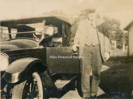 Henry with his car beside the store.