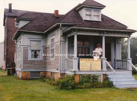 Michael Patrone is pictured standing(L) on the porch of 242 Langley when it was used as a House of Antiques.