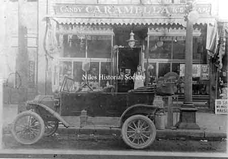 Prominent in the foreground of Carmella's Confectionery, located at 7 South Main Street, is one of the first Fords purchased in Niles, ca 1906.