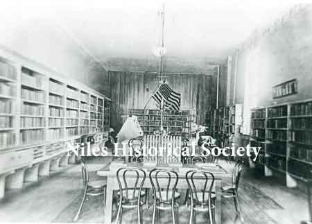 The interior of the Niles Library when it was in a rent free room owned by W. A. Thomas on the bend of Furnace Street (East State Street). It contained a total of 2,882 books and operated during the hours of 9-5, 6:30-8:30 daily.