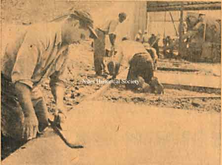 Workers completing cement sidewalks.
