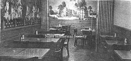 image is a view of the eating area with tables and the wall murals.