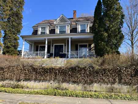 The house as it appears in 2023. Note the front steps have been relocated and the widow’s walk railings have been removed on the second floor.