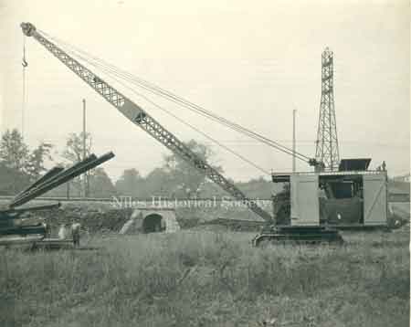 Steam shovel moving steel girders.