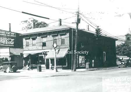 The corner of South Main Street and West Park Avenue showing the newspaper stand, the Lor-A-Lee diner in the right-hand back, the tower of the old City Building, and the advertisement that is on the side of Krieger's Pool Hall.