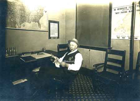A photo of Howard Ohl in his city building office. Writing on the back indicates he was with the sanitary police. 