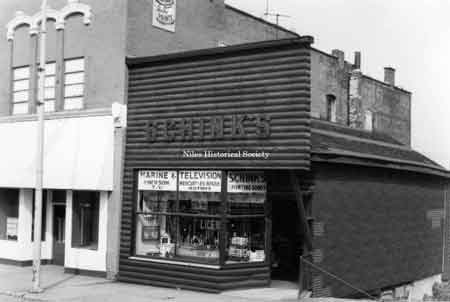 Photo taken of Schink's Marine and T.V. located at 33 E. State Street (east side) in down town Niles before urban renewal.